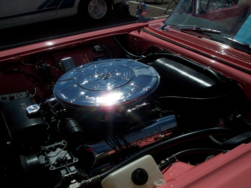 V8 engine bay with polished chrome round air cleaner in a red car