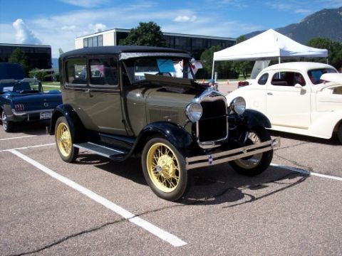 1972 Ford Ranchero - A classic 1929 Ford Model A Tudor is parked next to other vehicles under a tent.