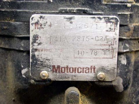 1996 Ford Bronco - Close-up of a riveted Motorcraft metal ID tag bolted to a dirty cast axle or differential housing, stamped with part number D4TA 2875-C2A,…