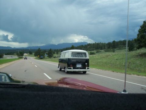 1972 Ford Ranchero - A two-tone Volkswagen Type 2 van travels down a highway under a cloudy sky.