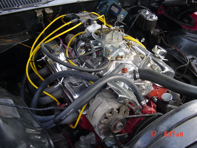 close-up of a V8 engine with chrome valve covers and a Holley carburetor