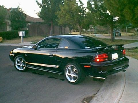 1991 Ford Bronco - Rear quarter view of a black 1996 Ford Mustang GT with aftermarket wheels.