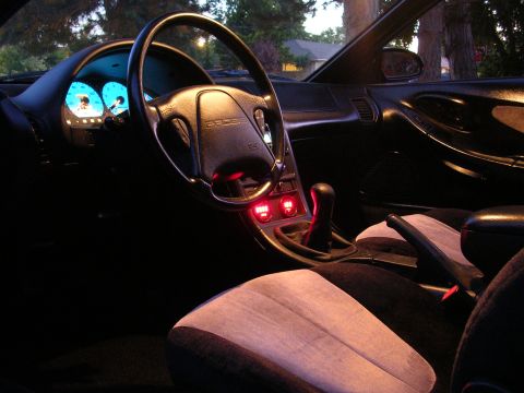 1996 Ford Probe - The illuminated dashboard and interior of a 1996 Ford Probe are visible at dusk.
