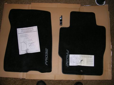 1996 Ford Probe - Two black floor mats, each with the word 'PROBE' embroidered, are laid out on cardboard with installation instructions.