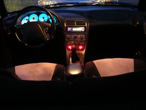 1996 Ford Probe - The illuminated interior of a 1996 Ford Probe at night, showing the dashboard and seats.