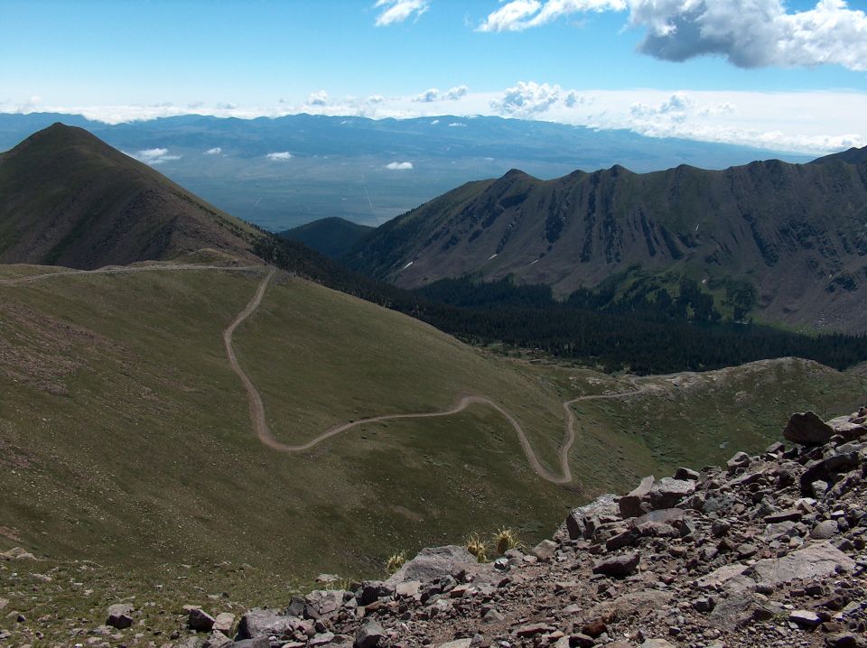 Mountain landscape with a winding dirt road and distant peaks