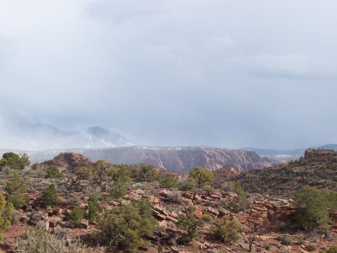 1991 Ford Bronco - A wide view of a desert canyon with rocky terrain and distant hazy mountains.