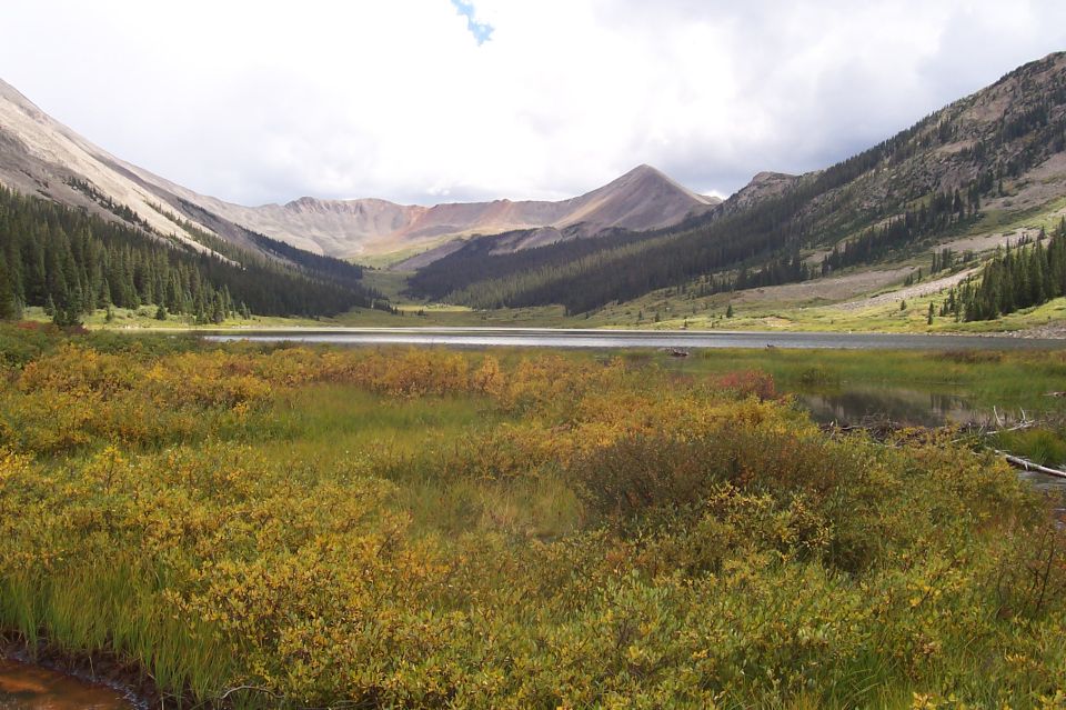 Mountain valley with a lake and autumn foliage in the foreground