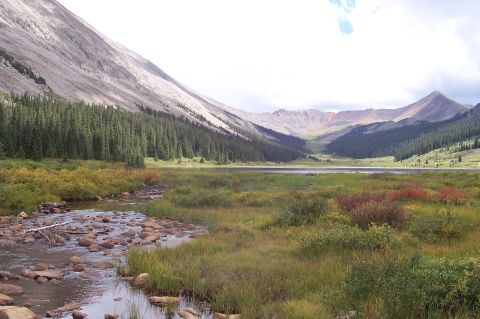 1991 Ford Bronco - A scenic view of a mountain valley a lake, dense pine forest, and a clear stream flowing over rocks.