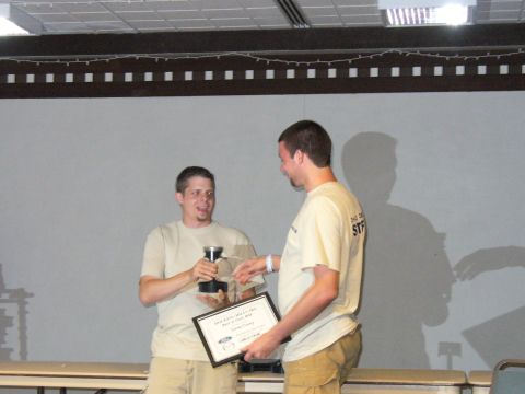 1991 Ford Probe - Two men are shown at an event, one receiving a trophy and a certificate from the other.