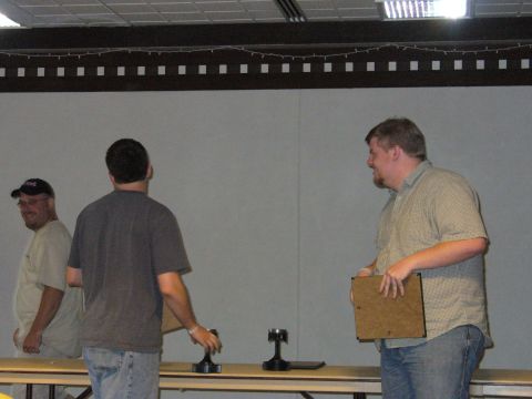 1991 Ford Probe - Three men are gathered behind a table displaying trophies, with one man on the left wearing a baseball cap.