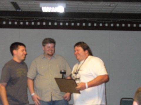 1991 Ford Probe - Three men are gathered, with one presenting a plaque to another.