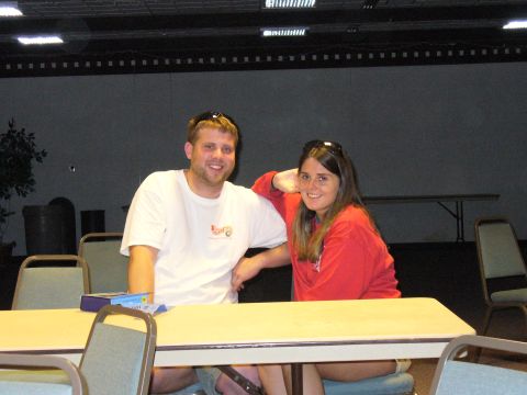 1991 Ford Probe - A man and woman pose for a photo while sitting at a table in what appears to be an indoor event space.