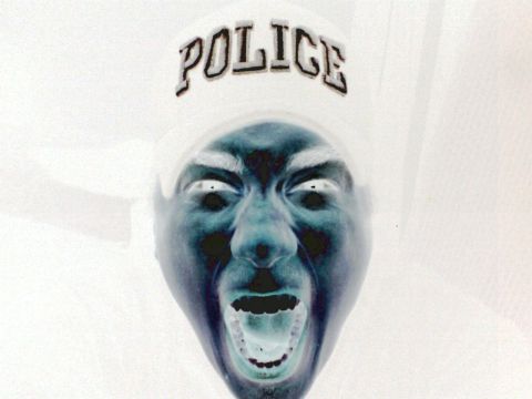 2001 Ford Crown Victoria - An inverted photograph shows a person's face with the word POLICE visible on their hat.