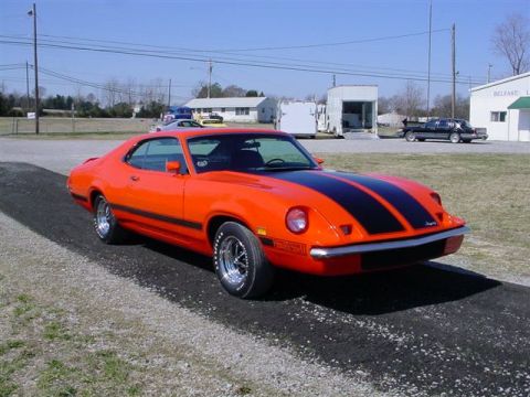 1972 Ford Ranchero - This 1972 Ford Ranchero is captured from a three-quarter front angle, highlighting its vibrant orange paint and bold black racing stripes.
