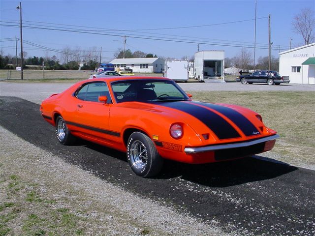Orange 1972 Ford Ranchero with black stripes, chrome wheels, and a slightly damaged front bumper