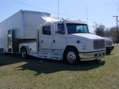 1972 Ford Ranchero - A white semi-truck is parked next to a silver trailer on a grassy area, with another vehicle visible in the background.