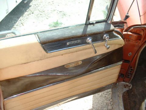 1972 Ford Ranchero - Interior view of a car's door panel, showing tan upholstery and chrome accents.