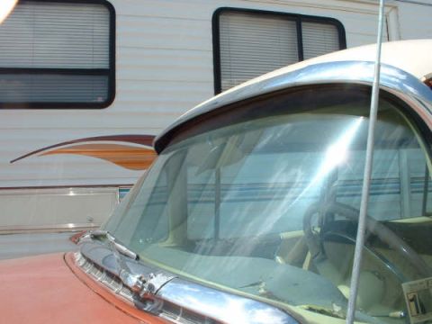 1972 Ford Ranchero - The front of a car is parked next to a recreational vehicle, showing a portion of the car's interior.