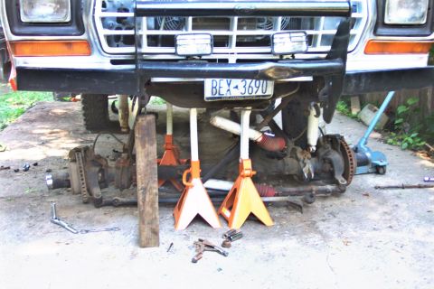 1978 Ford Bronco - Front end of a 1978 Ford Bronco undergoing suspension work, supported by jack stands.