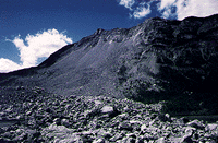 1995 Ford Bronco - A vast mountain landscape with a steep, rocky slope dominates the scene under a partly cloudy sky.