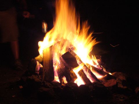 1991 Ford Probe - A nighttime bonfire with bright flames consuming logs, a website logo at the bottom.
