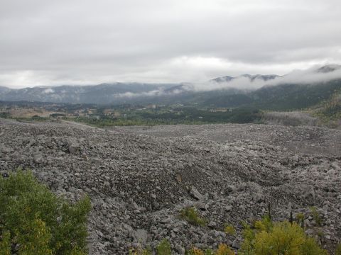 1995 Ford Bronco - A vast field of rocks and debris covers the landscape under a cloudy sky.