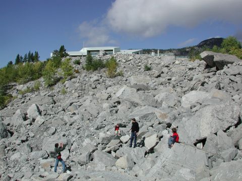 1995 Ford Bronco - A group of people explore a rocky terrain with a contemporary building visible in the distance.