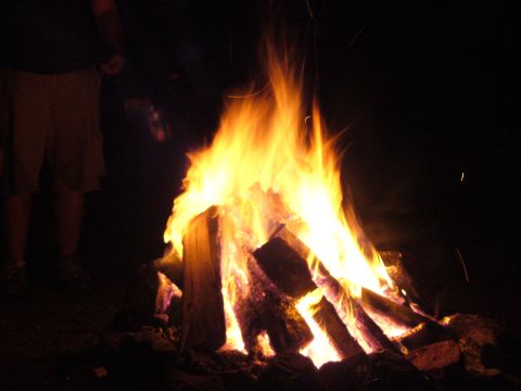 1991 Ford Probe - A roaring bonfire illuminates the night sky, with a person visible on the left side of the frame.