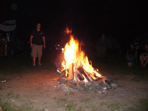 1991 Ford Probe - A group enjoys a nighttime campfire with tents set up in the background.