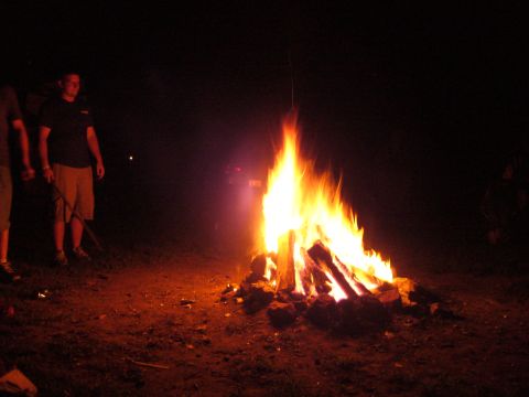 1991 Ford Probe - A group of people gather around a large bonfire in the dark.