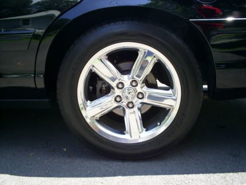2003 Mercury Marauder - Close-up of a chrome wheel on a 2003 Mercury Marauder, a five-spoke design and a central emblem.