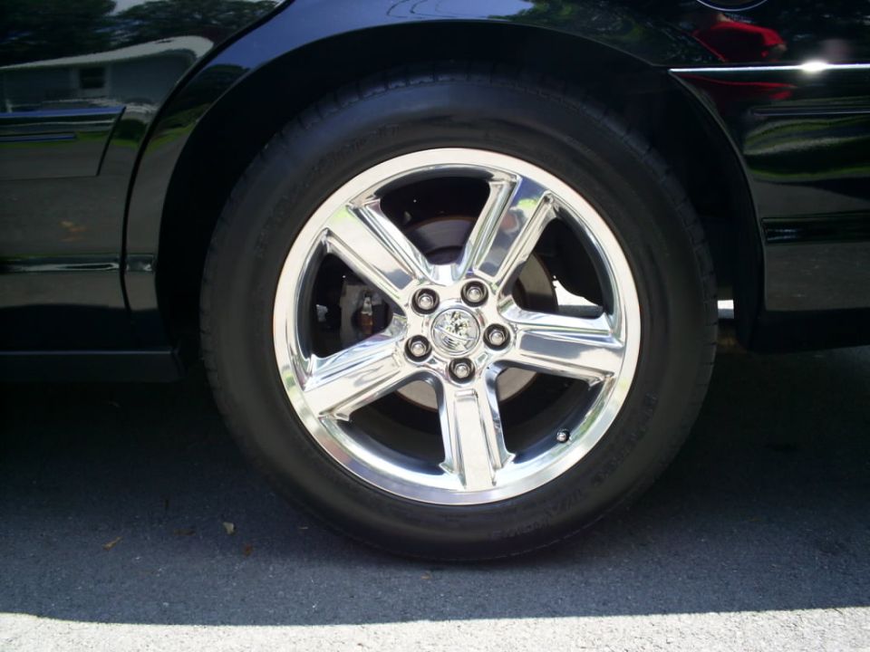 Chrome wheel with five spokes and a circular emblem, 2003 Mercury Marauder