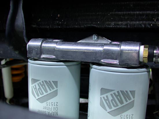 Aluminum dual oil filter mount with two white NAPA 21515 filters in engine bay