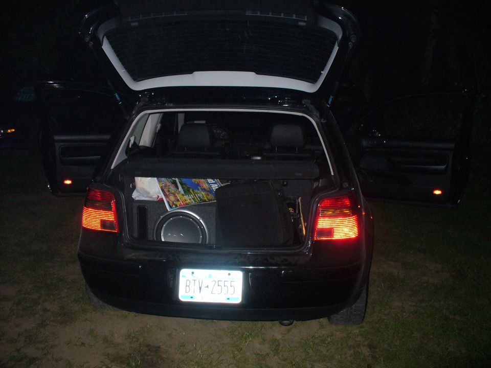 Black hatchback rear view with open trunk, subwoofer visible