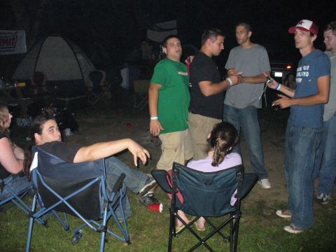 1991 Ford Probe - A group of friends gather outdoors at night, enjoying each other's company around a campsite.
