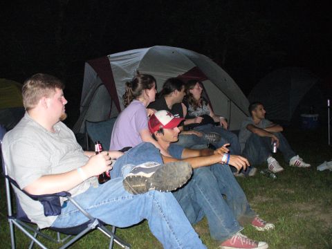 1991 Ford Probe - People gathered around tents at a campsite during the evening hours.