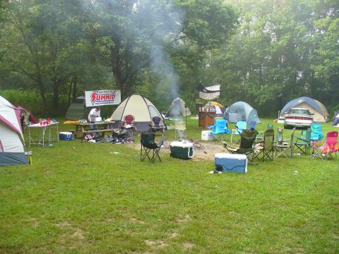 1991 Ford Probe - A campsite scene includes tents, chairs, and a car parked in the background.