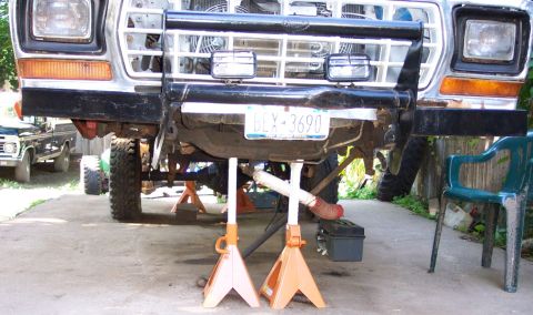 1978 Ford Bronco - Front view of a 1978 Ford Bronco on jack stands, with another Ford truck in the background.