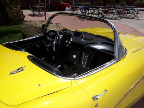 1972 Ford Ranchero - The interior of a bright yellow convertible is visible, with a black dashboard and seats.