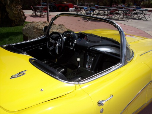 Interior of a yellow convertible sports car, showing the dashboard, steering wheel, and gear shift