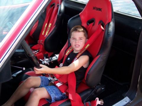 1972 Ford Ranchero - Child sits in a red racing seat with a roll cage visible.