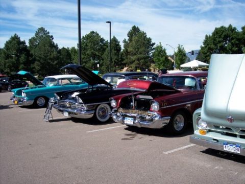 1972 Ford Ranchero - A collection of vintage automobiles are displayed with their hoods open at an outdoor car show under a partly cloudy sky.