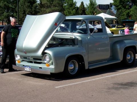 1972 Ford Ranchero - A light blue 1956 Ford F-100 pickup truck is displayed with its hood open at a car show.