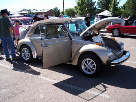 1972 Ford Ranchero - A tan 1972 Volkswagen Beetle convertible is displayed at a car show, with its hood open and driver's door ajar.