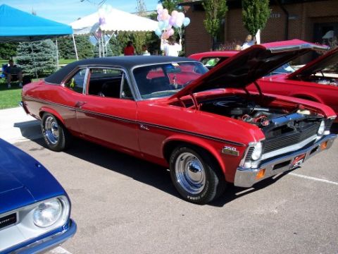1972 Ford Ranchero - A red coupe, possibly a 1970 Nova, is displayed with its hood open at an outdoor car show.