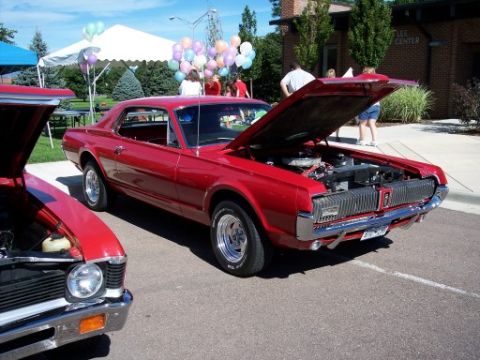 1972 Ford Ranchero - A red 1969 Mercury Cougar is displayed at an outdoor car show with its hood up.