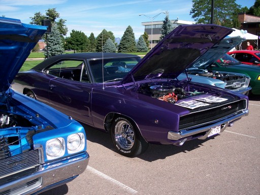 Purple 1968 Dodge Charger with hood open, parked next to a blue car