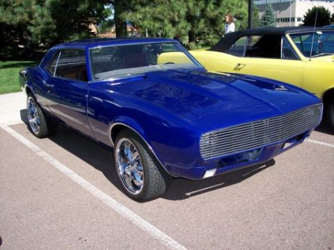 1972 Ford Ranchero - A blue 1967 Chevrolet Camaro is parked at a car show next to a yellow convertible.