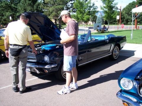 1972 Ford Ranchero - Two men examine a classic convertible at an outdoor car show.